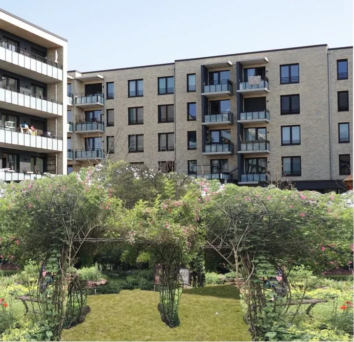 Der BlauHausGarten im Überseequartier, mit Wohnungskomplexen im Hintergrund. Eine Mischung aus Stadt und Natur.